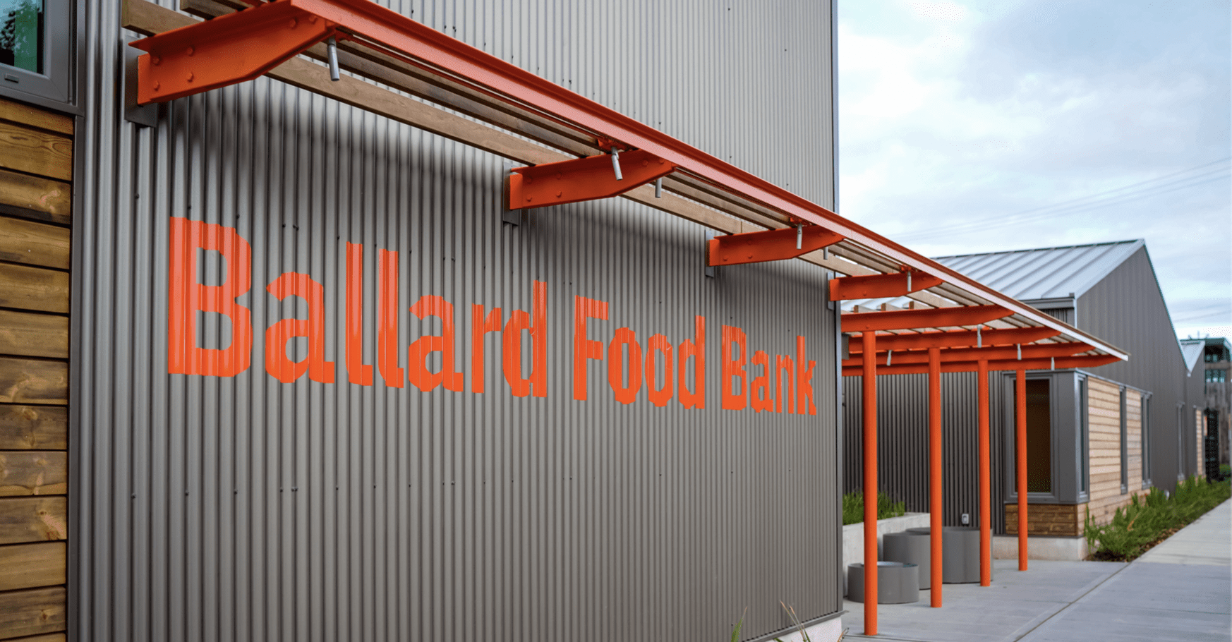 A gray, textured wall reads "Ballard Food Bank" in orange letters