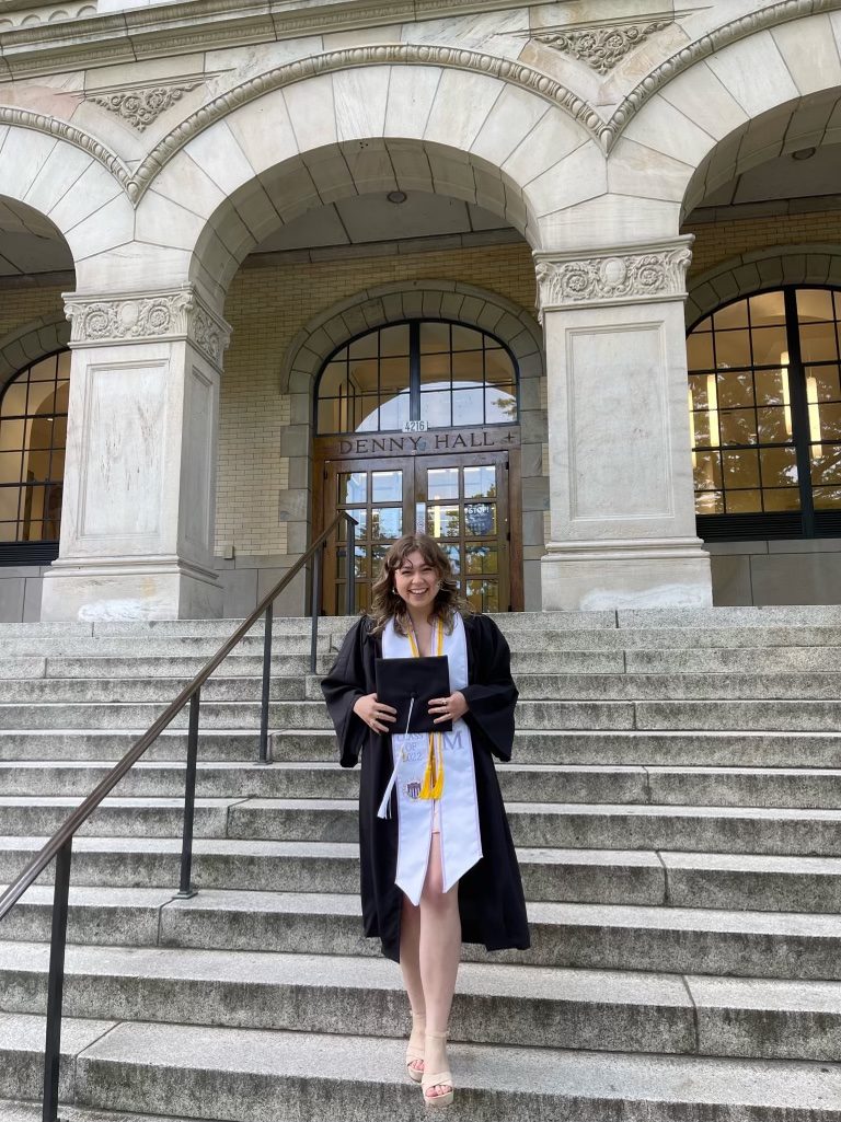 Caroline with her graduation cap standing on steps